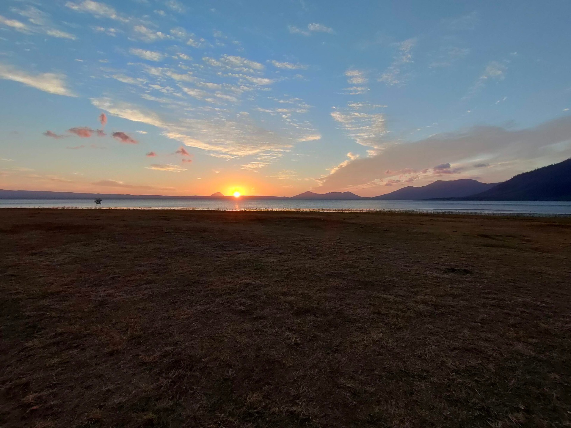 Sunset over a lake with mountains at a lakeside free camp